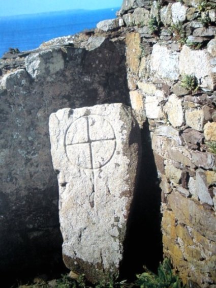 Within the ancient ruined chapel of St Non is a stone slab with a 6th/7th century incised Latin ring cross carved onto it. The stone used to be embedded in the wall, but now stands up-right. Some prehistoric standing stones are scattered around the chapel, perhaps once part of a stone circle or cromlech. St Non, daughter of Prince Cynyr, was the mother of St David. She died at Dirinon in Brittany.