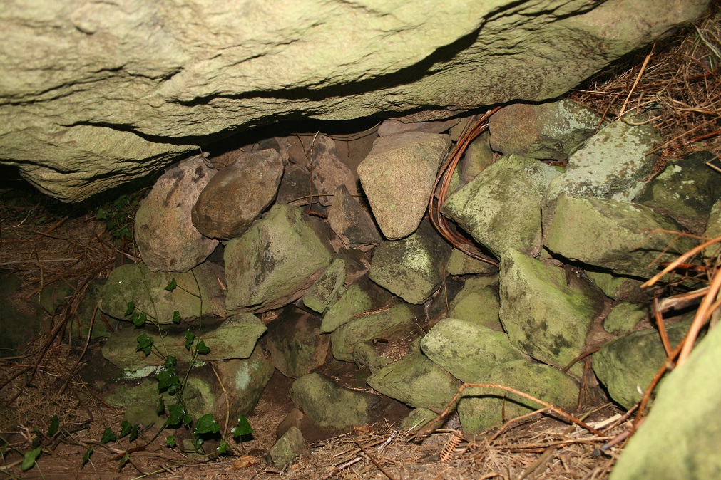 Under the capstone, it does not touch the ground anywhere but is propped up on all sides.