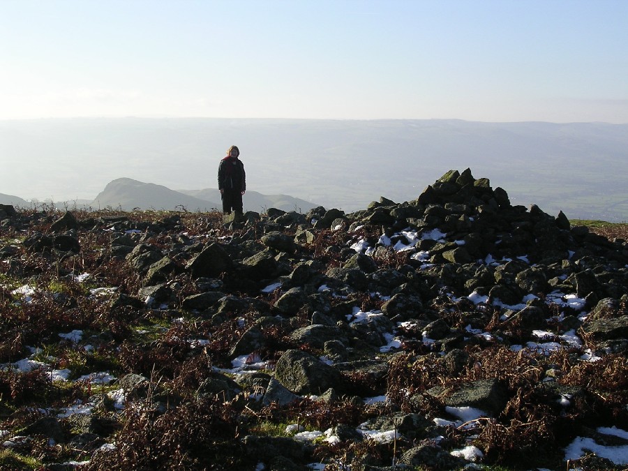 The first substantial cairn on Corndon Hill, Midwinter Solstice 2004; a friend, 'Wintertrees', stands on the far side of the cairn for an idea of scale of the monument.
Roundton Hillfort is upon the hill to the left.