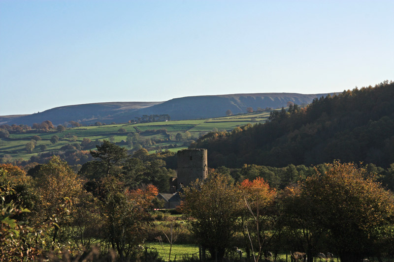 Looking South, towards the Llangattock escarpment, with Tretower castle in the foreground. 
  The cairn is on the skyline at about 2 o'clock. Visible even from several miles away.